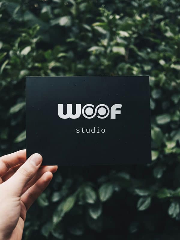 Logo von WOOF Studio, dem Design Studio in Hamburg für professionelles Branding und Webdesign, präsentiert vor einer grünen Pflanzenwand.